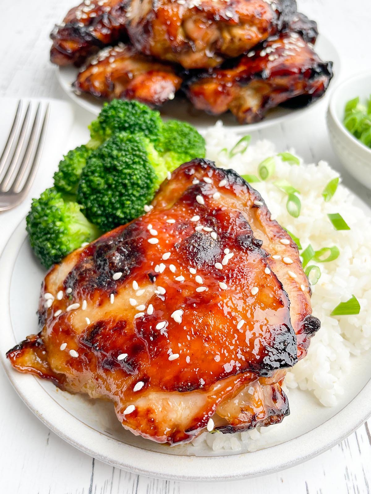 air fryer teriyaki chicken thigh on a white plate with white rice and broccoli