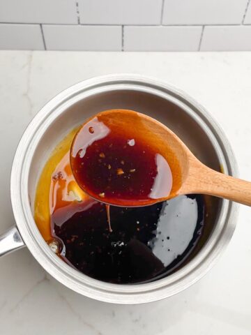 teriyaki sauce in a saucepan with a wooden spoon.