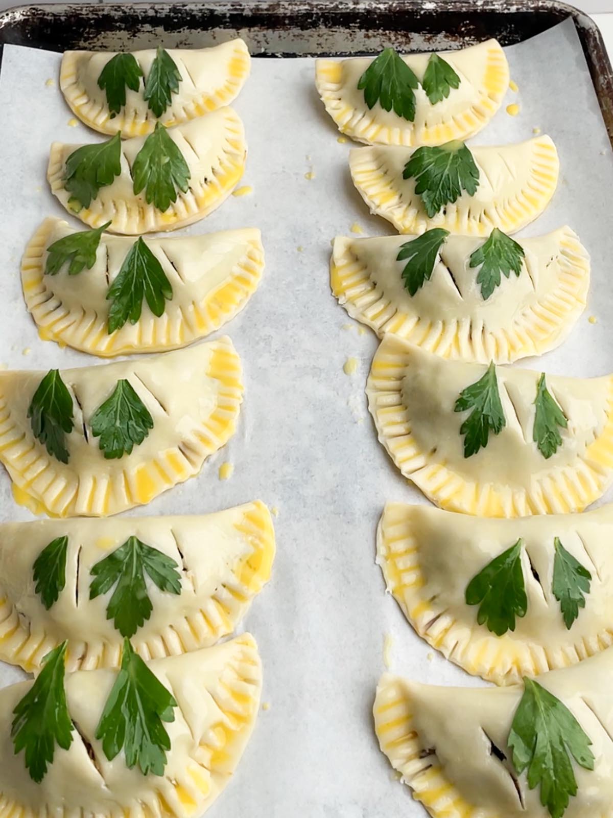 unbaked empanadas on a baking sheet