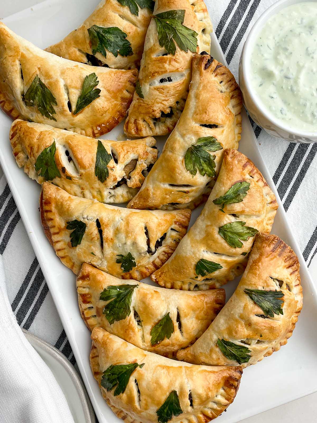 baked vegetarian empanadas on a white platter