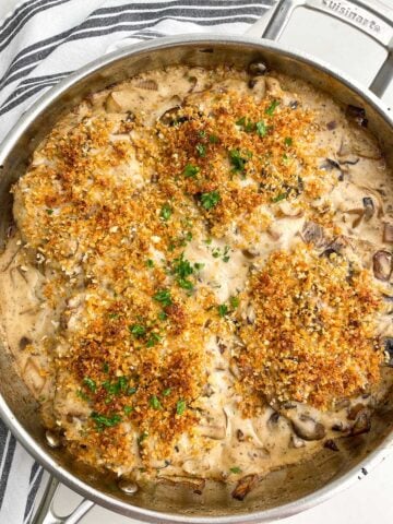 baked pork chops with cream of mushroom soup recipe in stainless steel skillet.