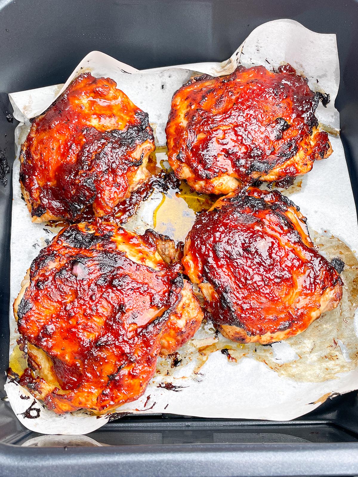 bone in skin on bbq chicken thighs in air fryer basket