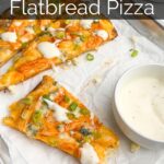 slices of buffalo chicken flatbread on a baking sheet lined with parchment paper