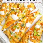 slices of buffalo chicken flatbread on a baking sheet lined with parchment paper