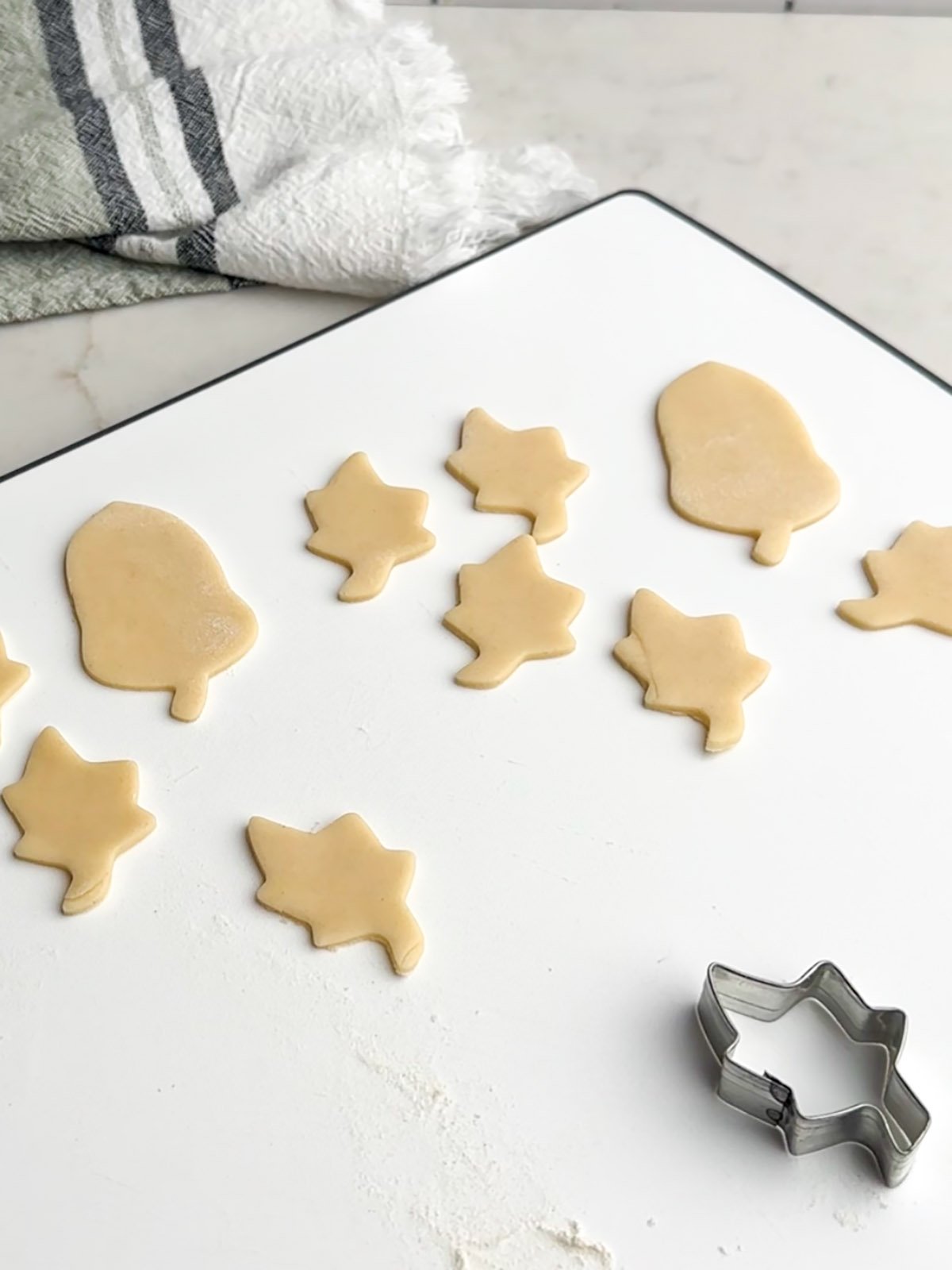 Pie dough cutouts on a white cutting board.