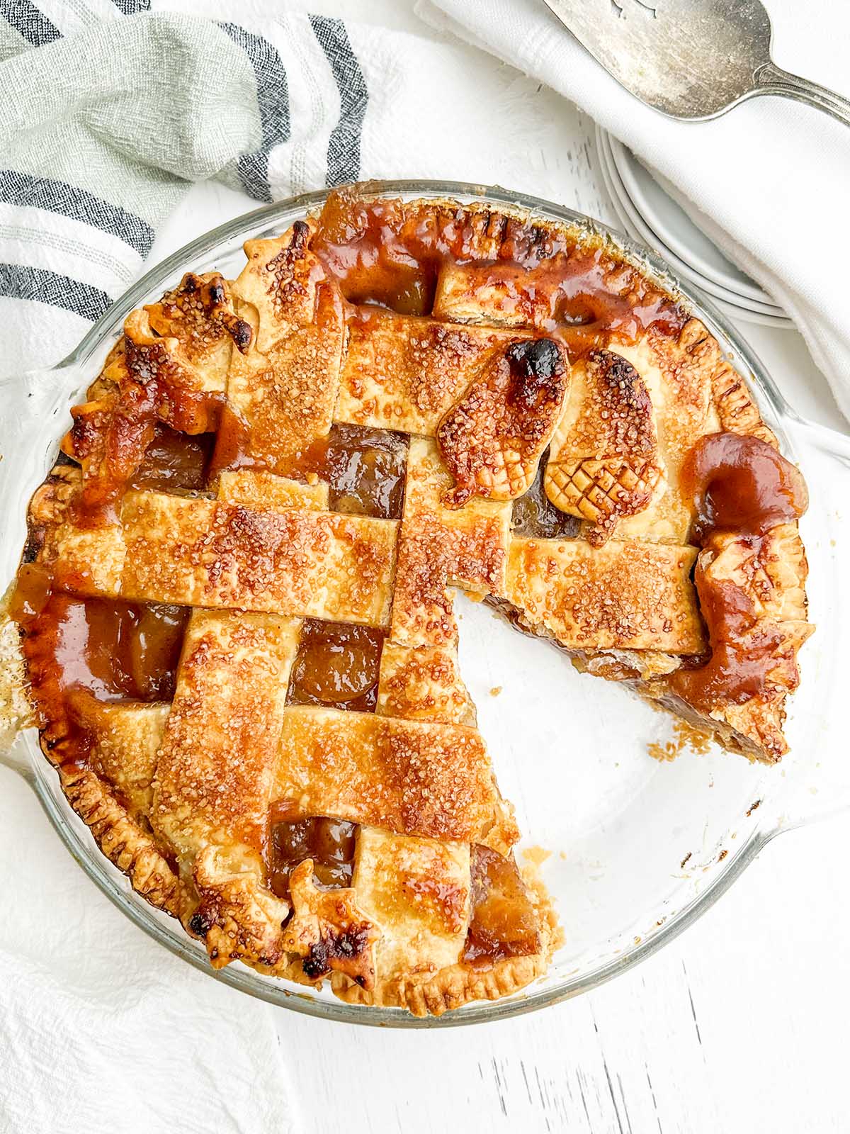 Canned apple pie in a clear pie plate with one piece missing.