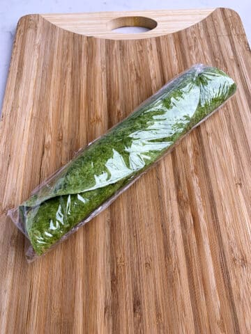 Chicken Cranberry Salad Pinwheel Sandwich rolled up in plastic wrap. 