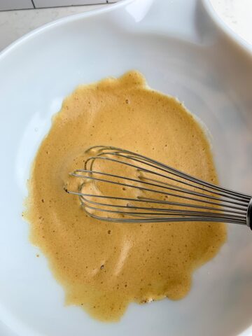 beaten egg whites, vanilla, salt, and espresso powder in a white bowl.