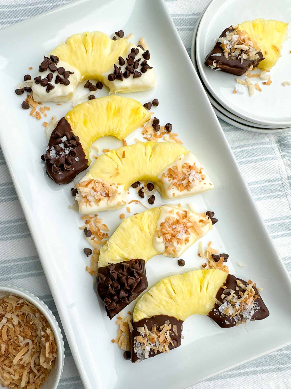 chocolate covered pineapple half rings on a white platter