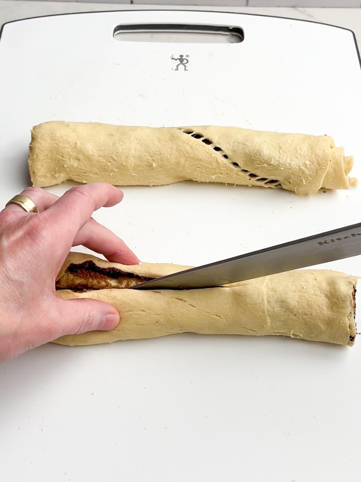 hand holding a knife cutting the dough in half