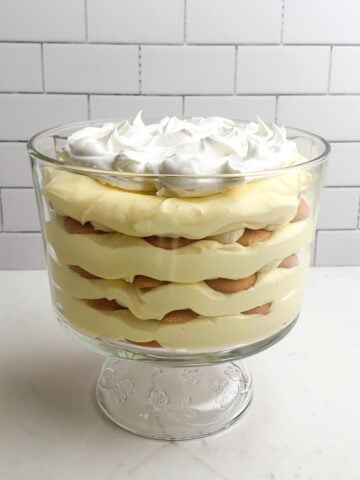 easy banana pudding in a trifle dish on a white counter.