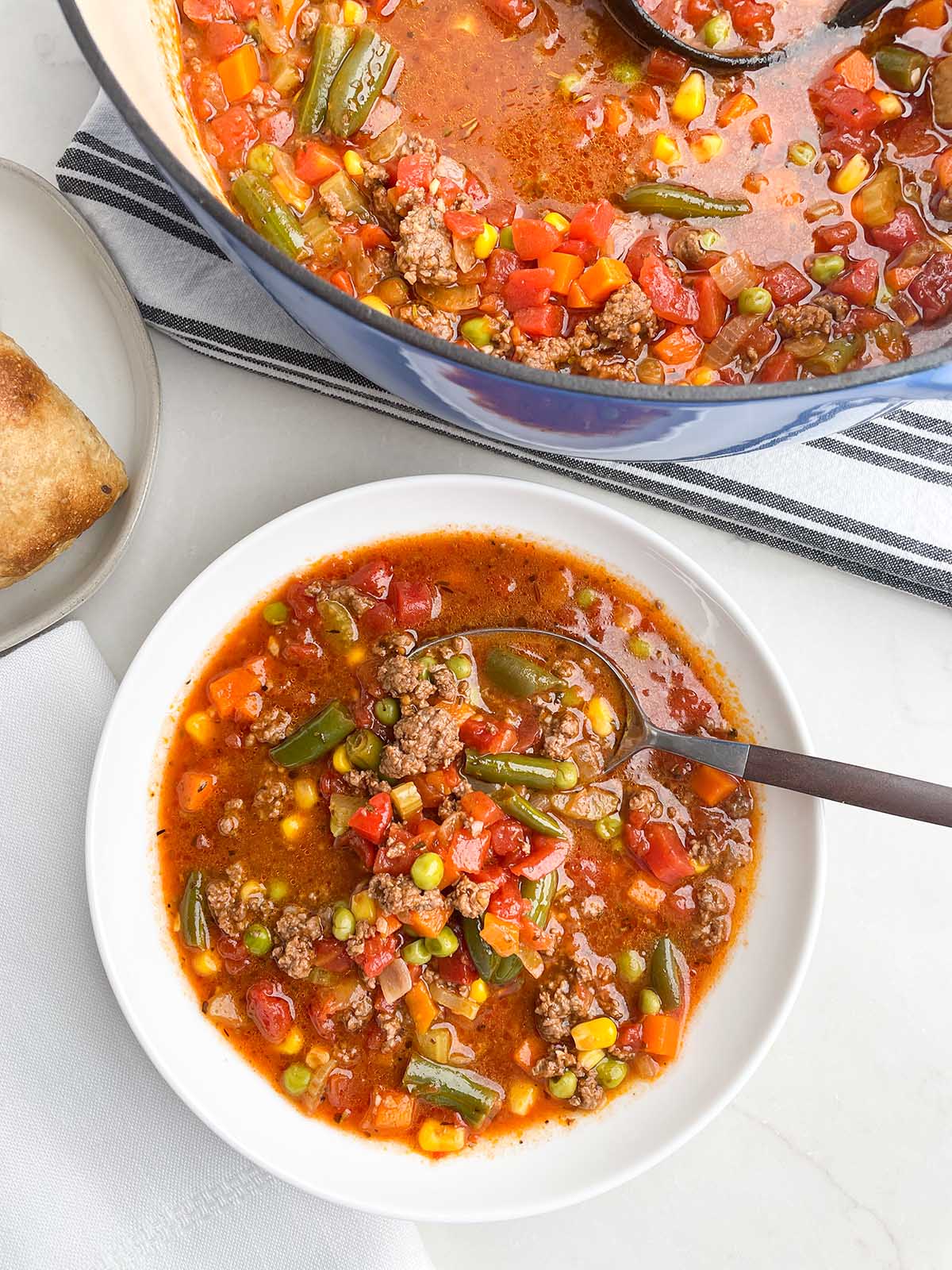 ground beef vegetable soup recipe in a white bowl.