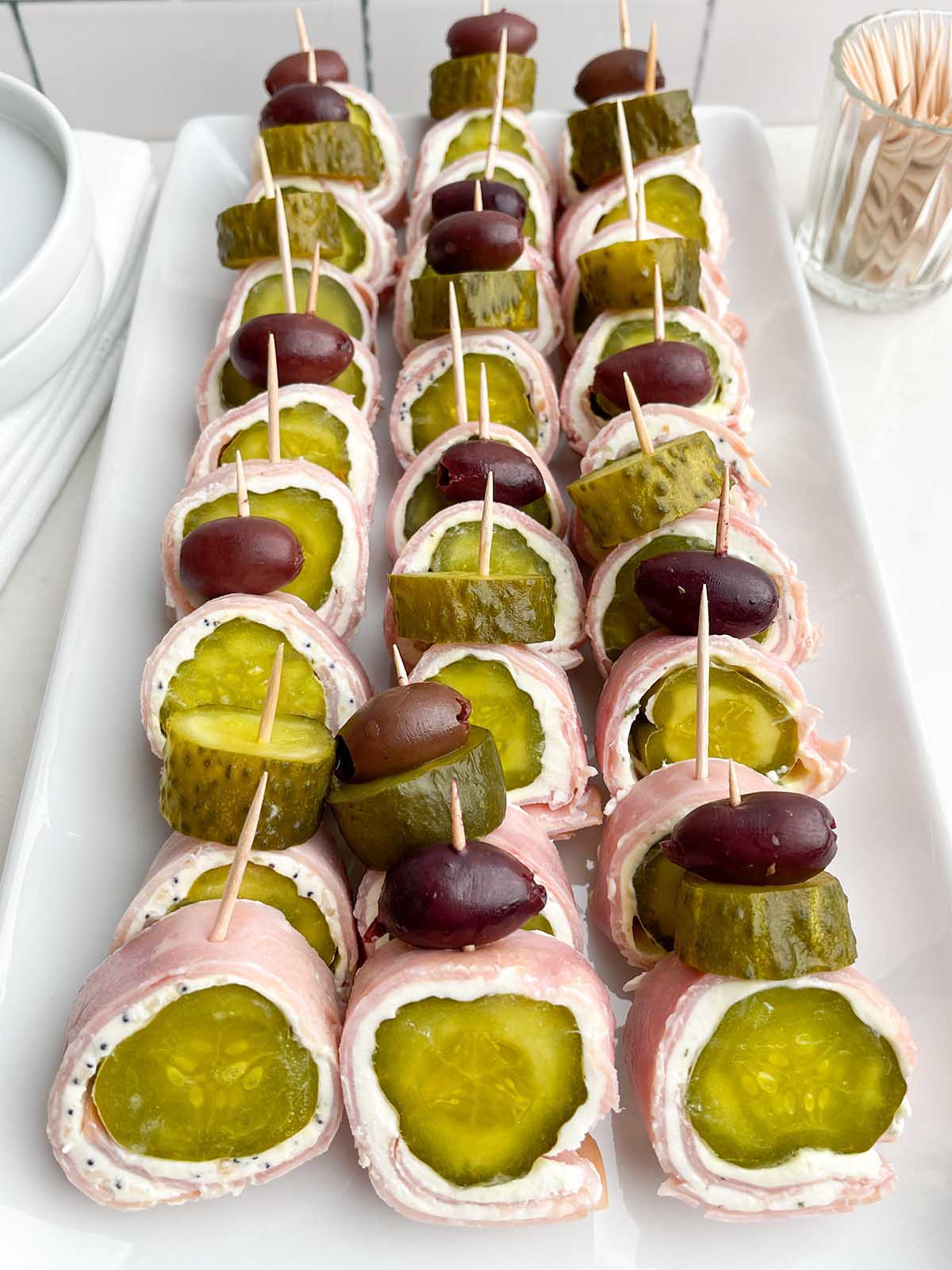 white platter with ham and pickle roll ups