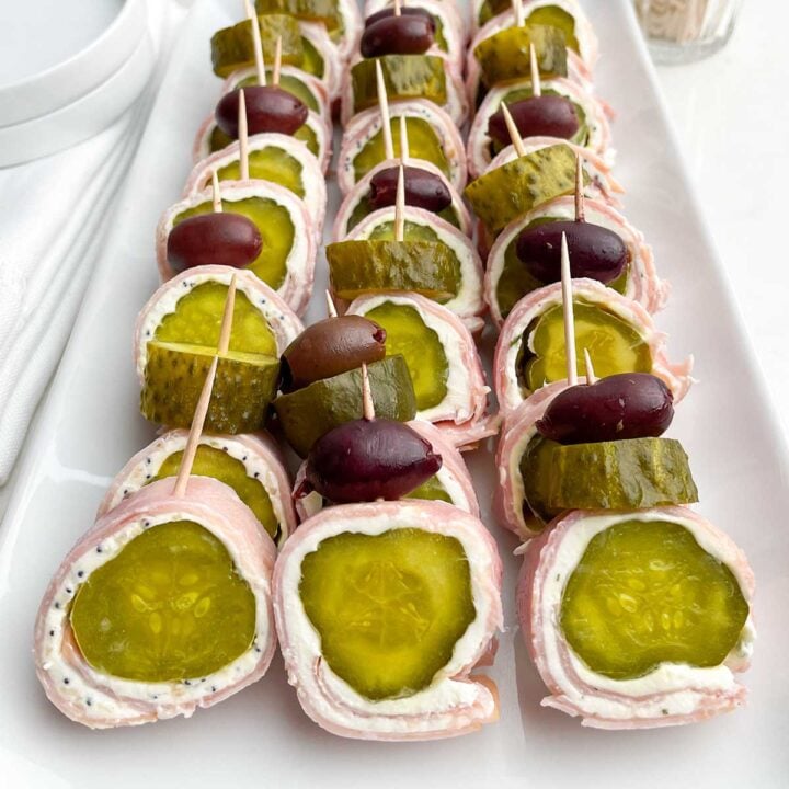 white platter with ham and pickle roll ups