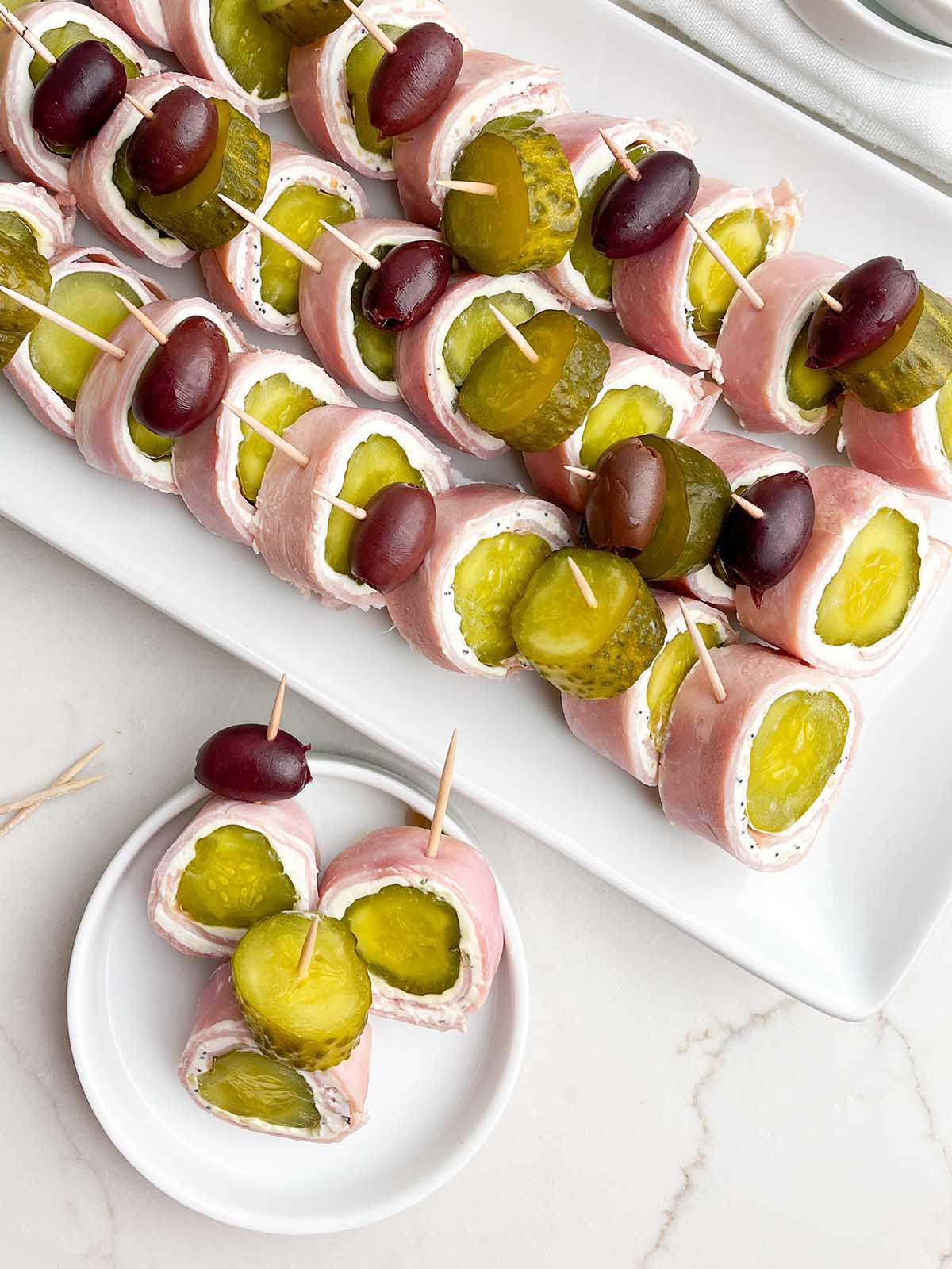 small white plate with three ham and pickle roll ups