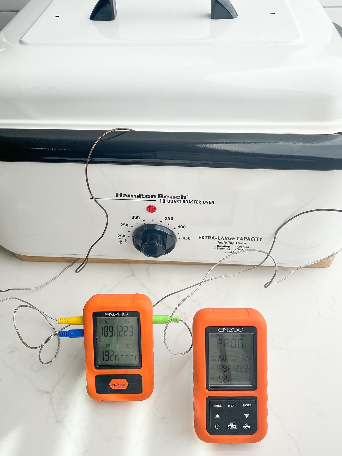digital thermometer with probes going into a roaster oven