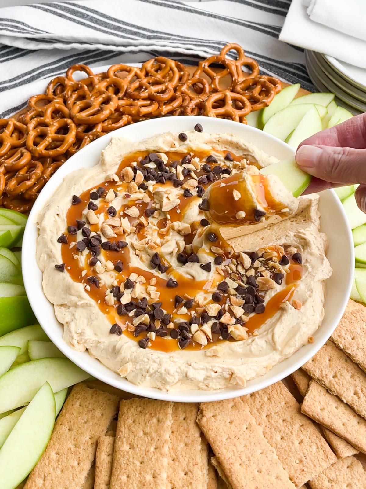 white bowl of caramel apple dip on a tray of dippers