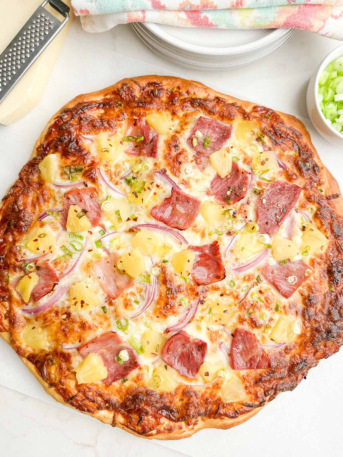 baked pineapple pizza on white countertop