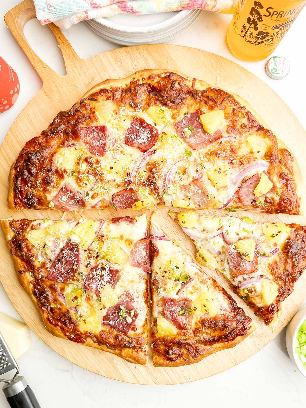 baked pineapple pizza on wooden cutting board