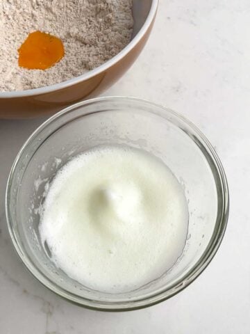 beaten egg whites in a clear bowl.