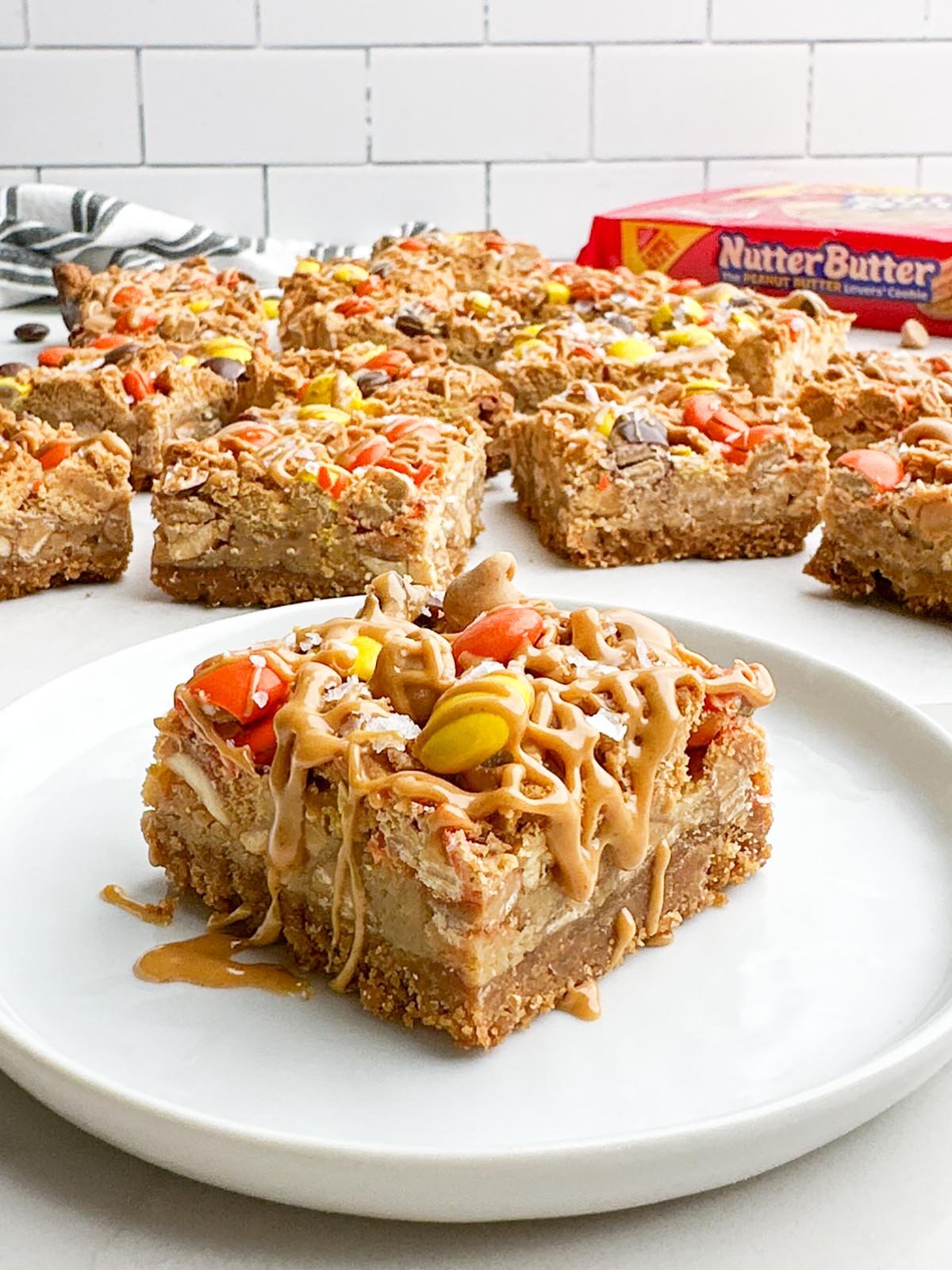 A Nutter Butter bar drizzled with peanut butter on a white plate.