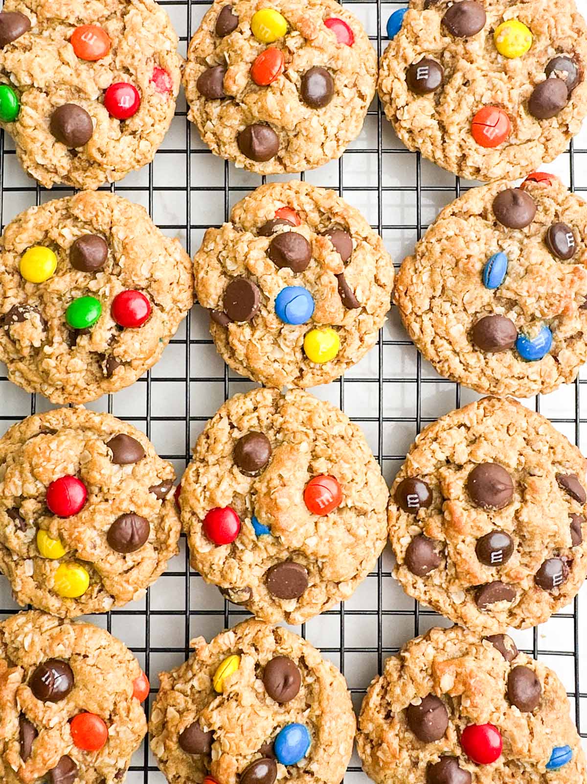 Monster cookies on a wire baking rack.