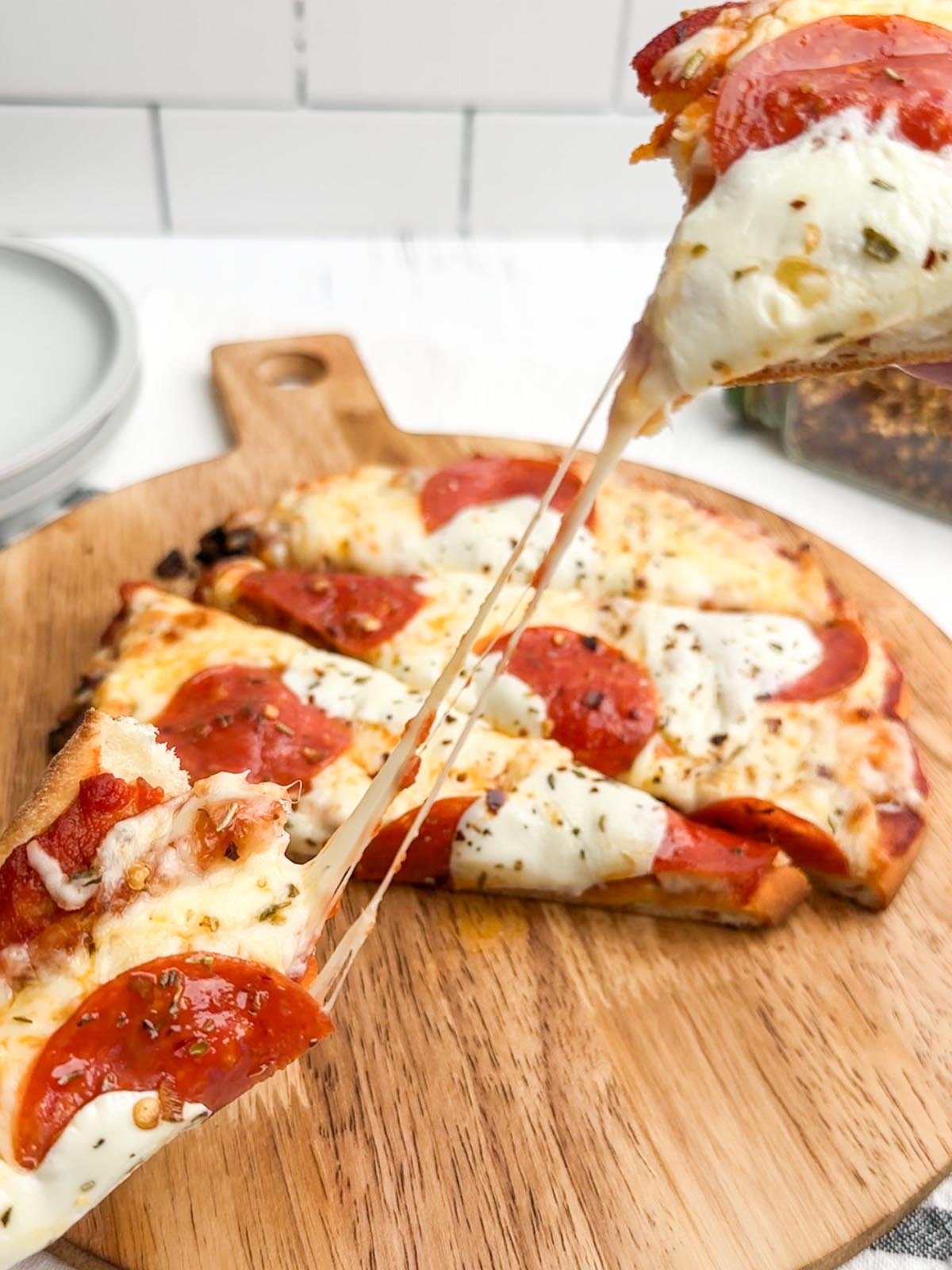 two pieces of pizza being pulled apart with cheese pull in between