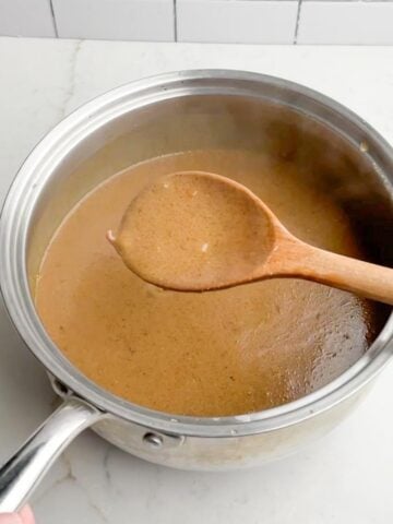 Gravy in a saucepan with a wooden spoon. 