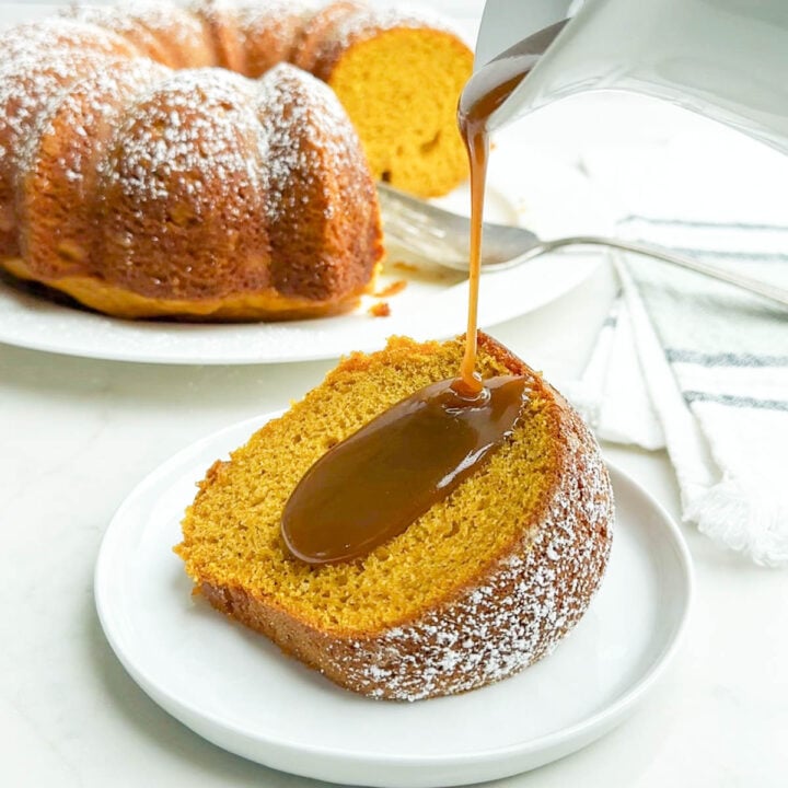 pumpkin cake with yellow cake mix on a white plate with caramel sauce being drizzled on top