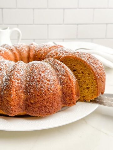 eye level view of pumpkin cake with yellow cake mix on a white plate.