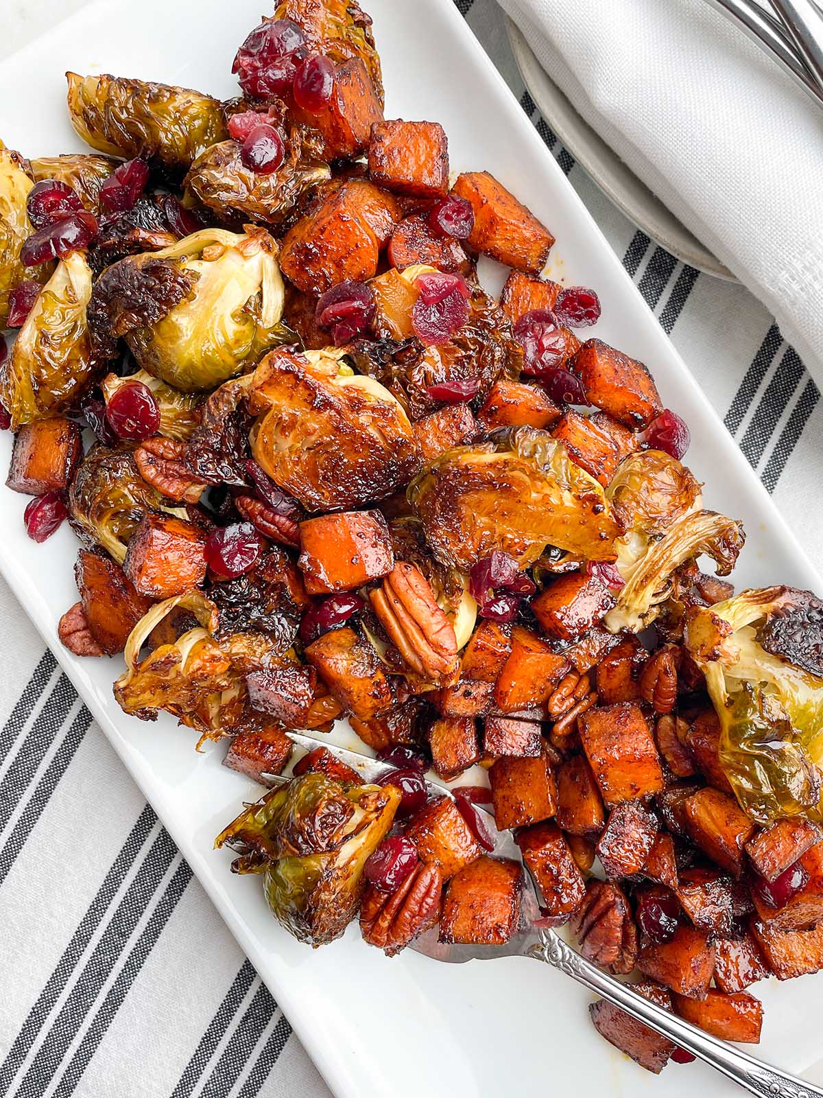 roasted brussels sprouts and sweet potatoes on white platter