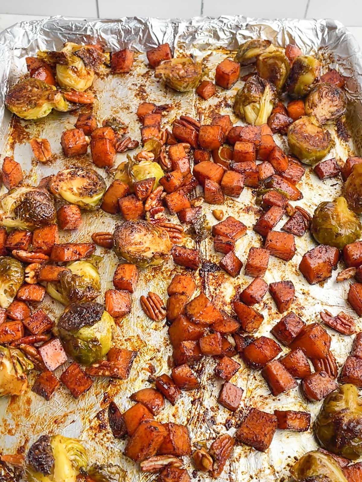 roasted brussels sprouts and sweet potatoes on baking sheet