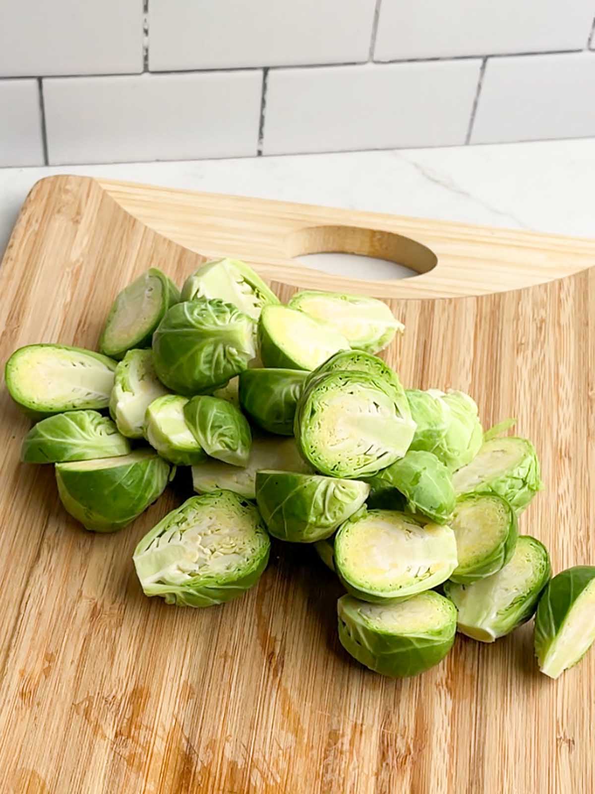 halved brussels sprouts on a wooden cutting board